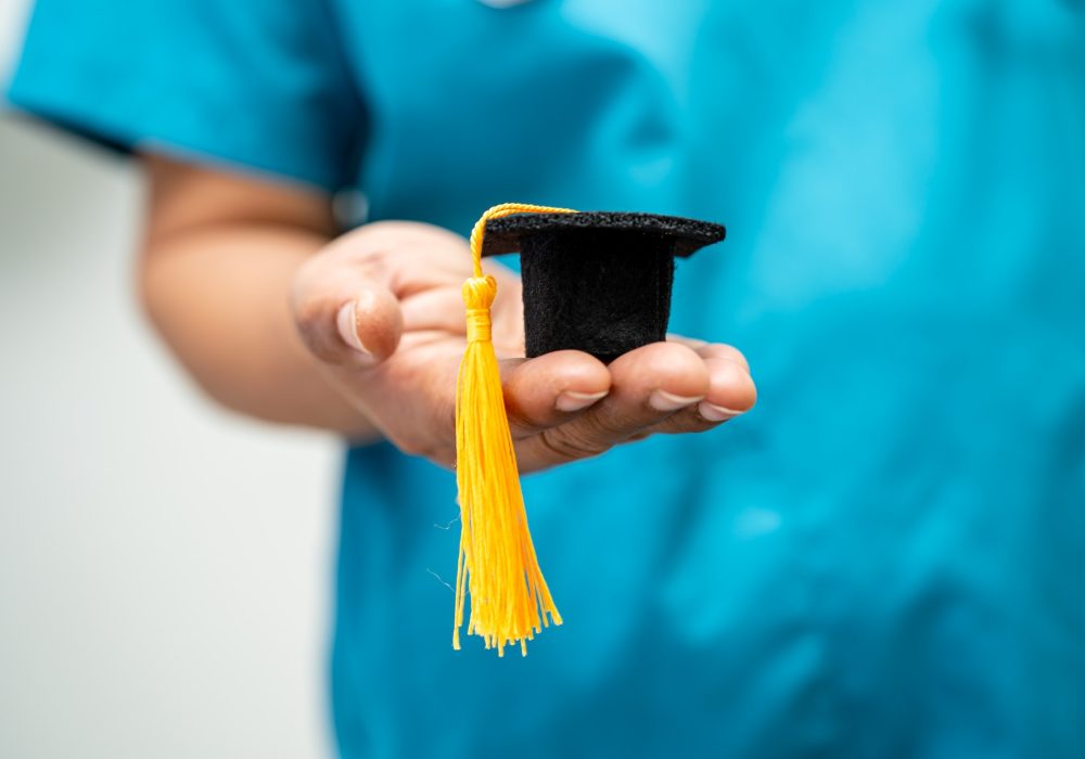 Doctor holding graduation gap hat in nursing hospital.